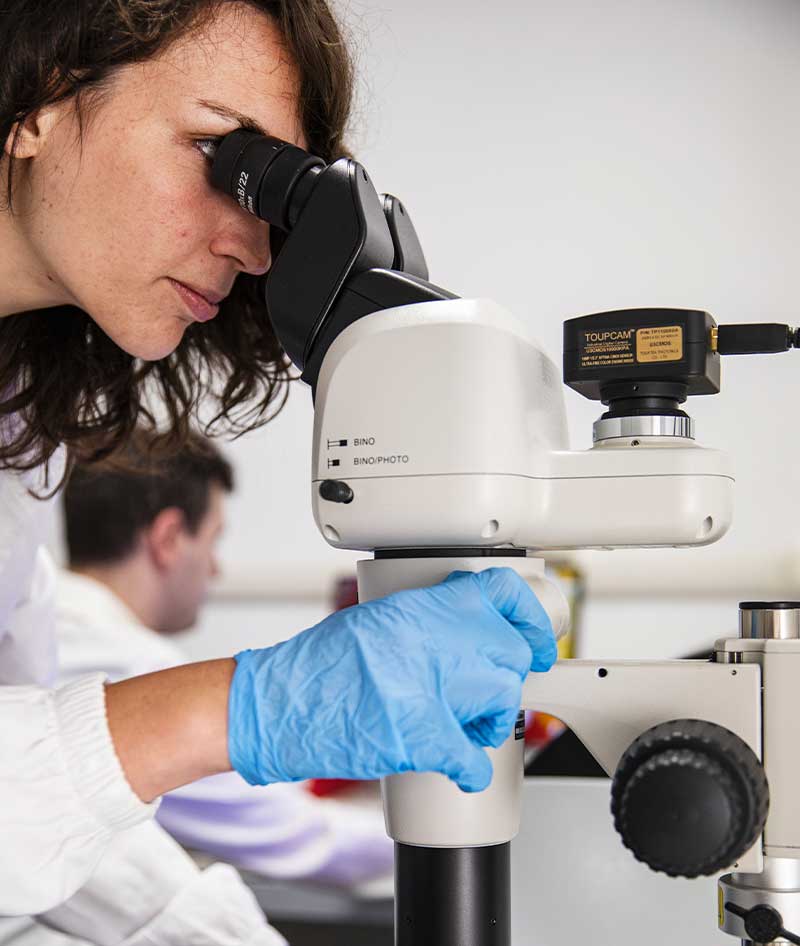 Riciclare è ricercare: una ragazza analizza del materiale al microscopio